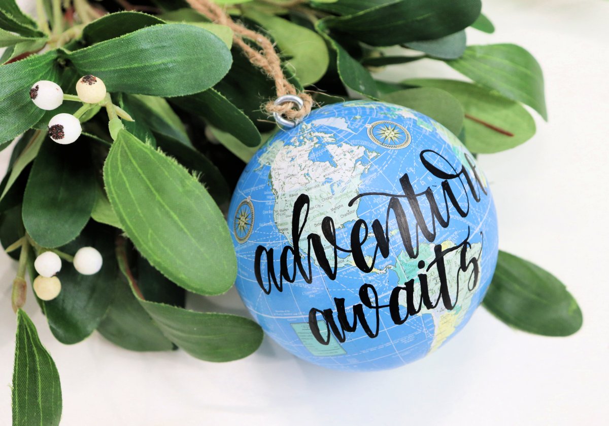 Image contains mistletoe and a blue globe ornament with the words, "adventure awaits."