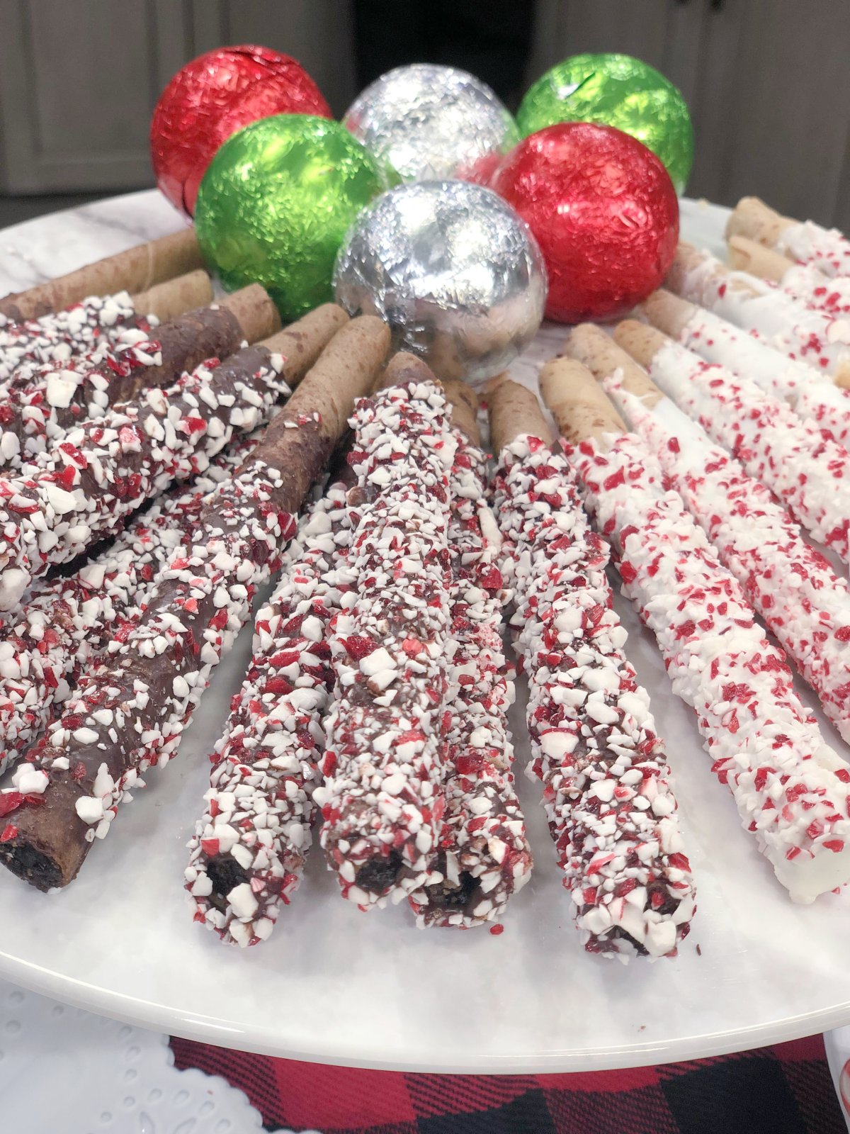 Image contains wrapped hot chocolate bombs and chocolate dipped pirouette cookies.