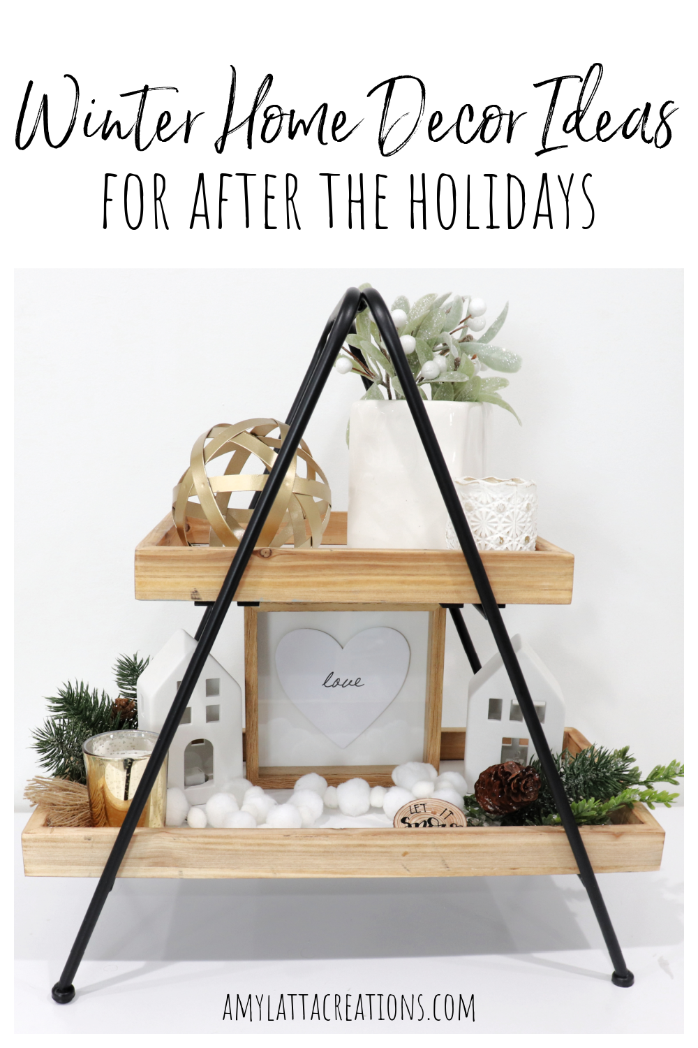 Image contains a two-tiered decorative tray styled with greenery and white and gold accents for winter.