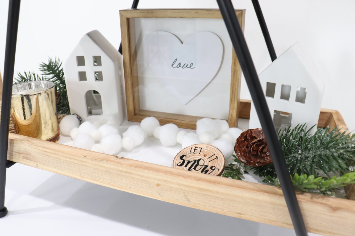 Image contains a styled wooden tray with assorted winter decor.