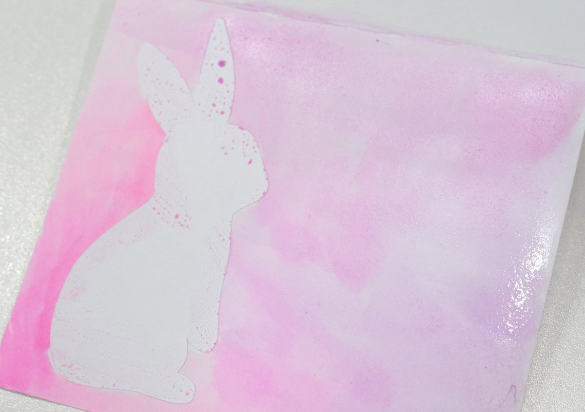 Image contains a watercolored placecard with a white bunny sticker on the left side.