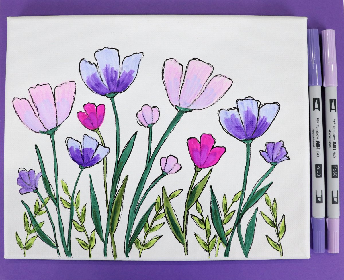 Image contains a horizontal white canvas covered with pink and purple flowers and green leaves. It sits on a purple background with two purple markers next to it.