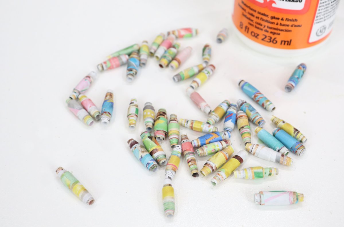 Image contains numerous multicolored rolled paper beads on a white background.