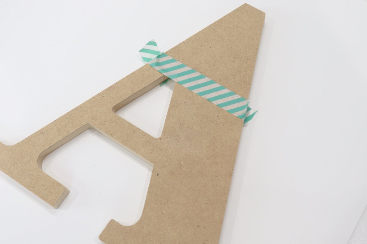 Image contains a wooden letter A with a piece of washi tape dividing off the top third.
