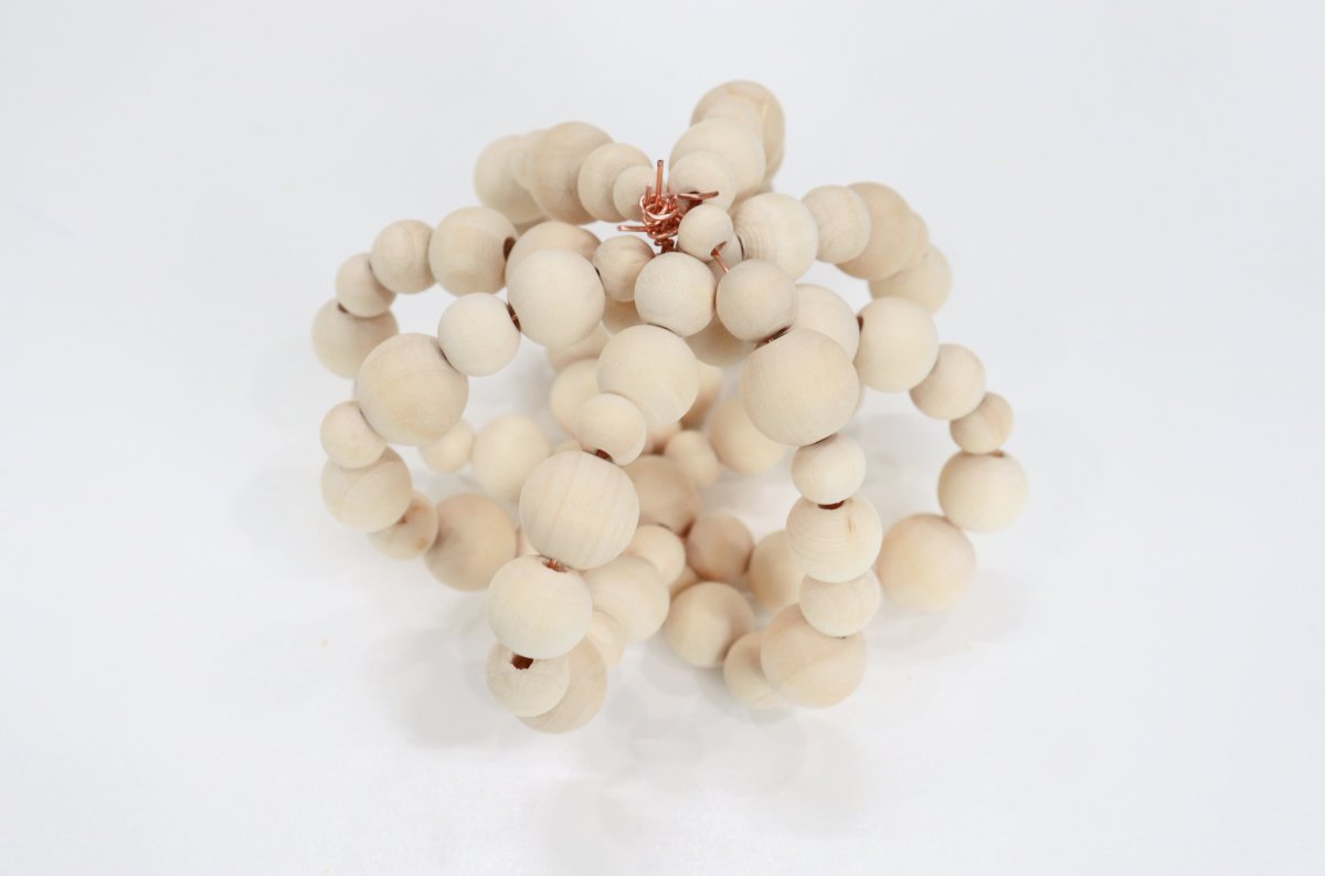 Image contains eight strands of wooden beads formed into the shape of a pumpkin.