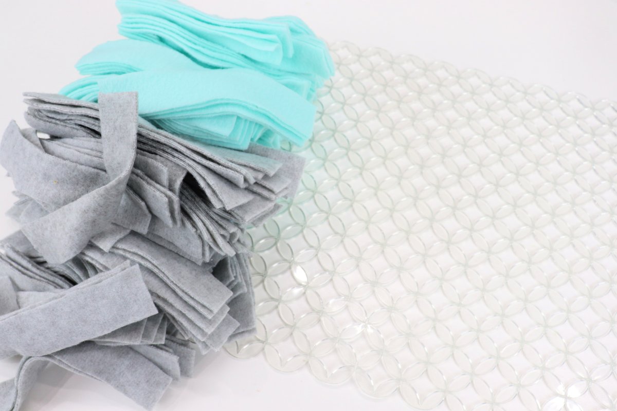 Image contains teal and grey fleece strips and a clear kitchen sink mat.