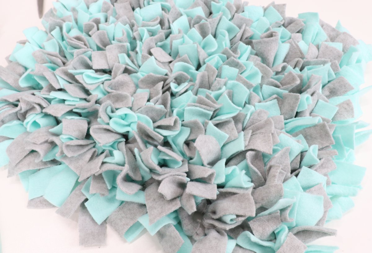 Image is a teal and gray snuffle mat for dogs on a white background.