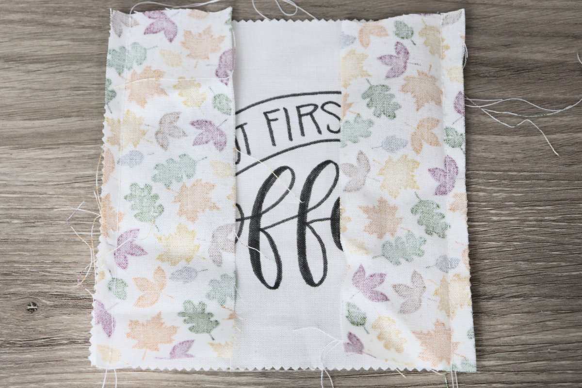 Image contains a lettered fabric square with two fabric strips pinned to the left and right sides.