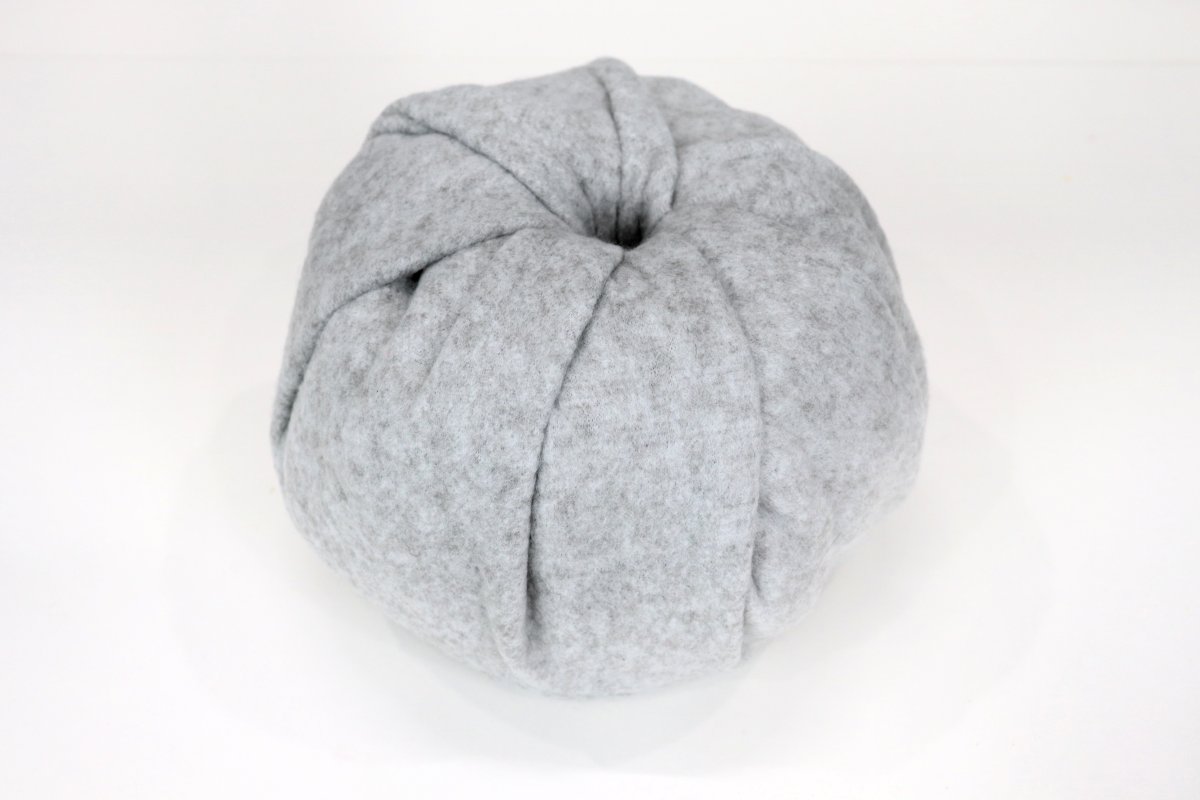 Image contains a roll of toilet paper wrapped in grey fleece.
