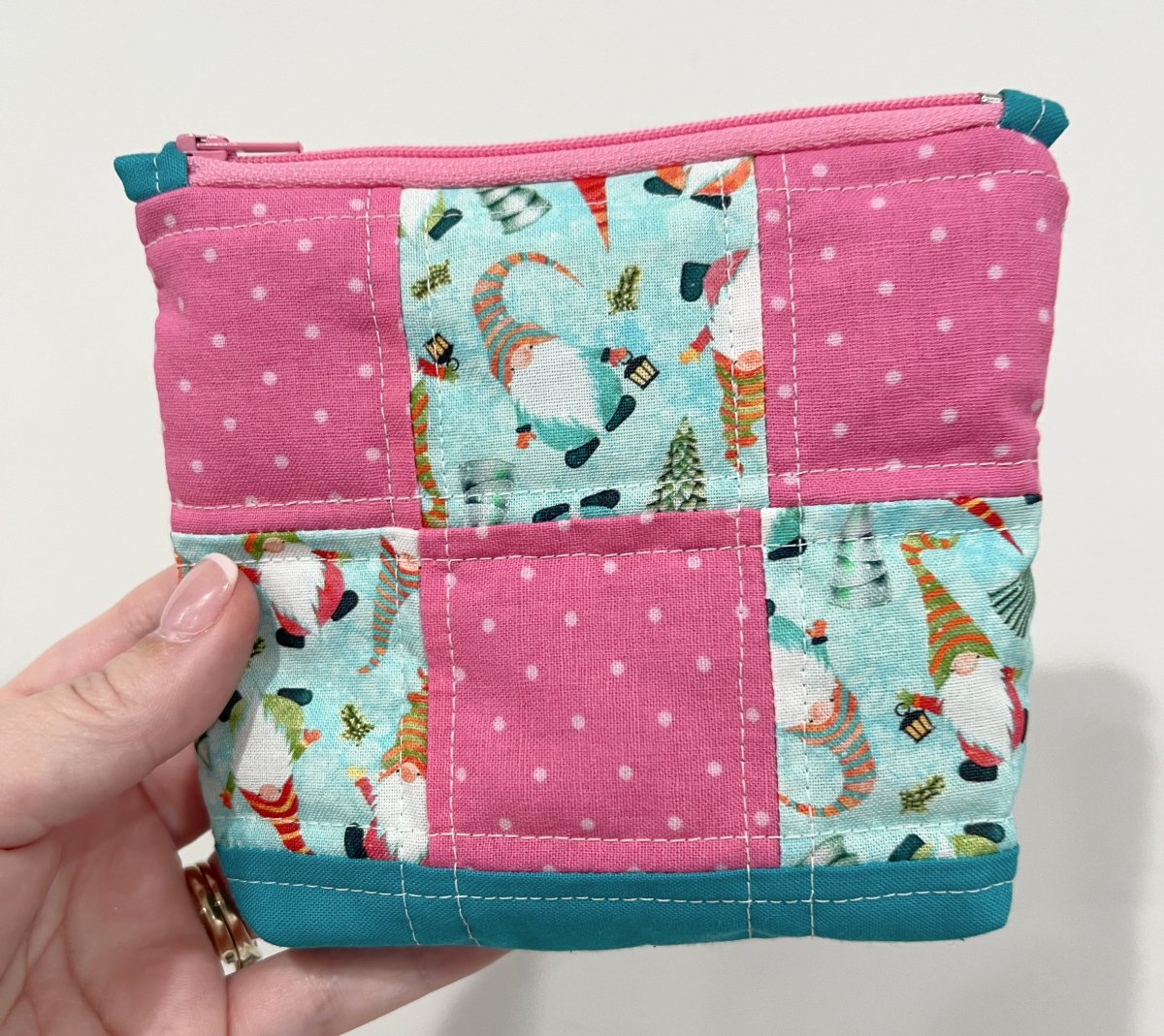 Image contains Amy’s hand holding a small patchwork pouch.