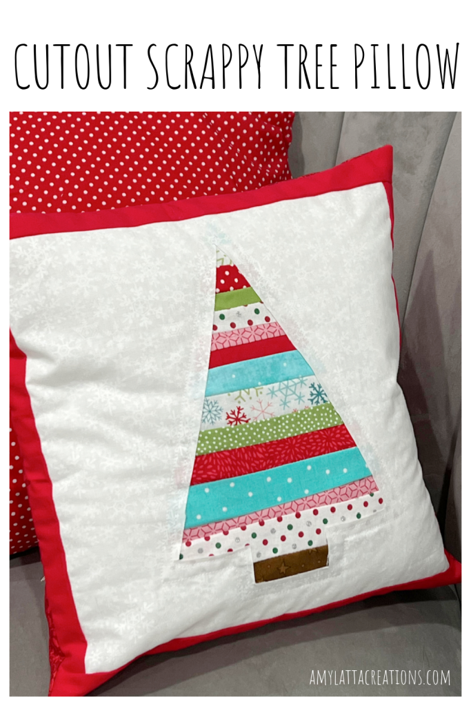 Image contains a white pillow with a multicolored striped tree in the center and a red border.