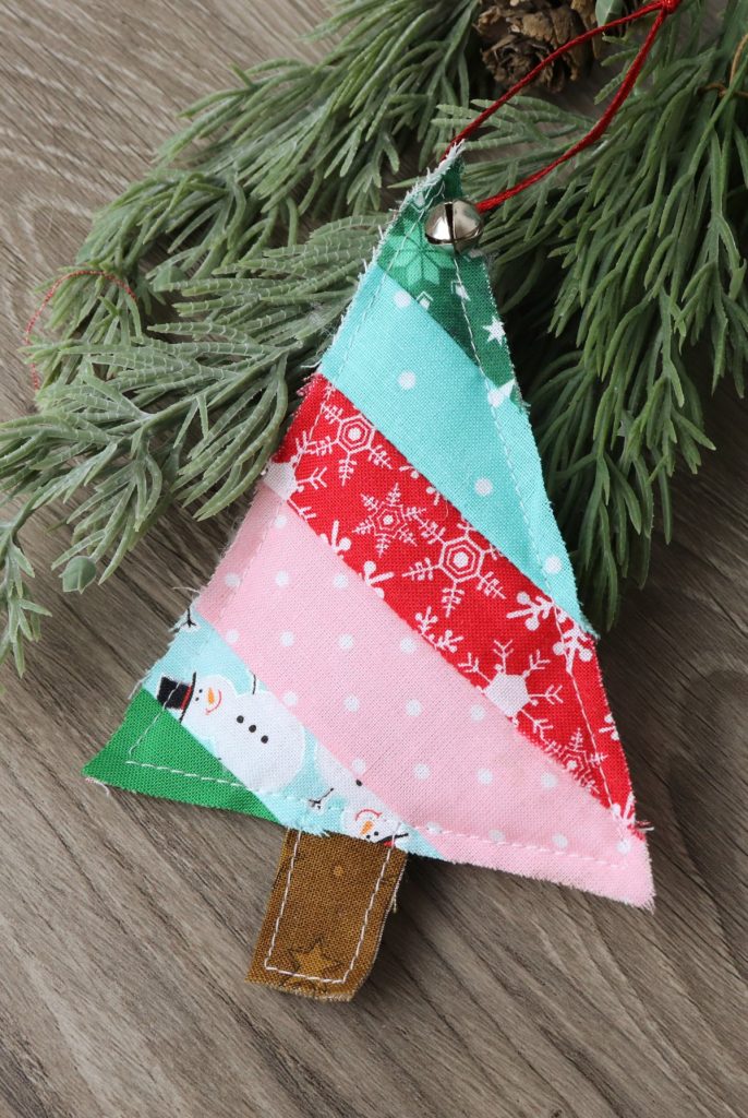 Image contains a tree shaped ornament made from fabric scraps sewn in a diagonal stripe pattern.