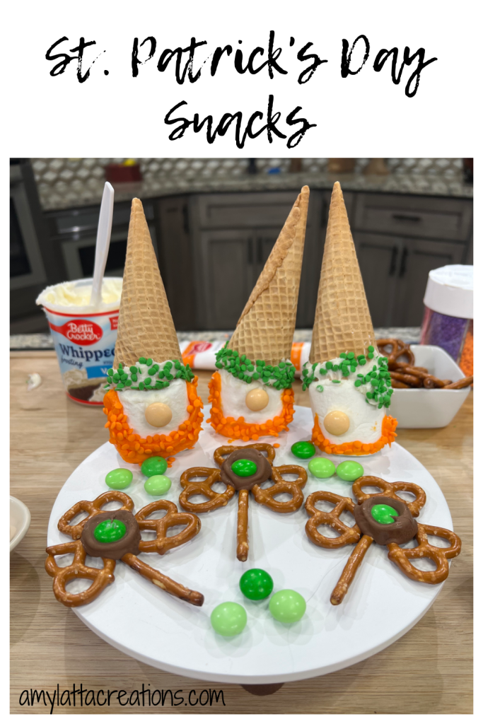 Image contains three Leprechaun Gnome Snacks and three shamrock pretzel snacks on a white tray, accented with green M&Ms.