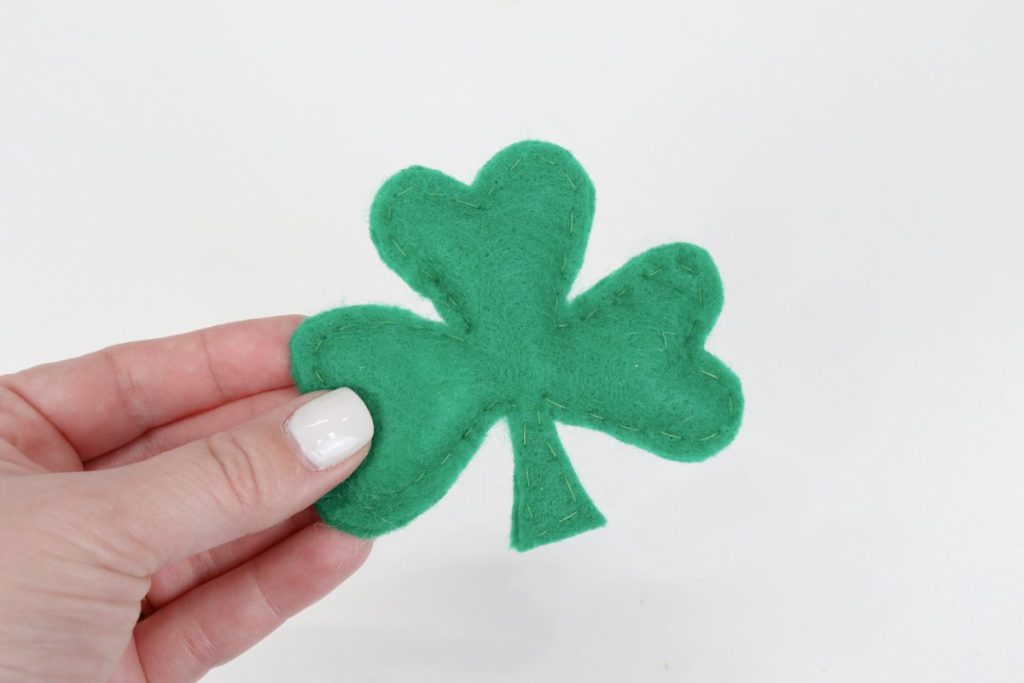 Image contains Amy's hand holding a plush green felt shamrock.