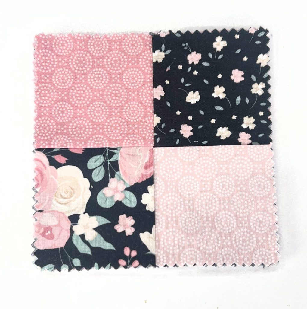 Image contains a stack of fabric with four pieces overlapped on top to form small squares.