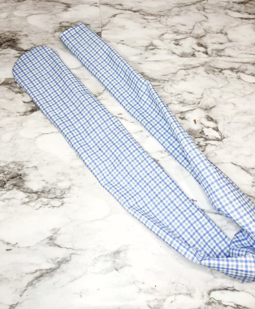 Image contains a long tube made from blue and white plaid fabric.