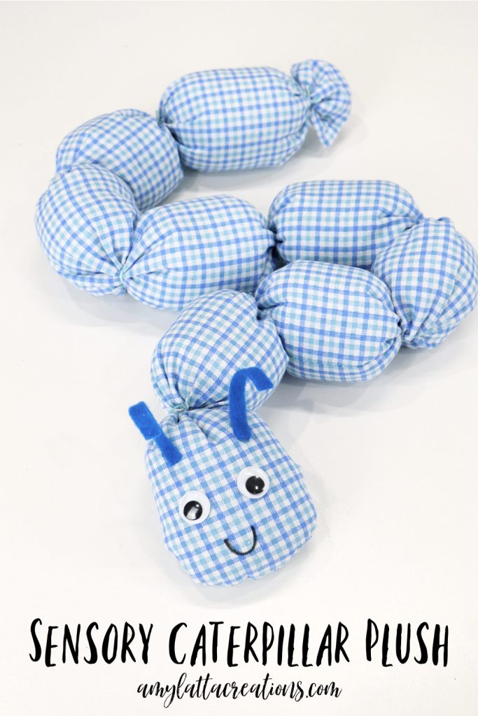 Image contains a plush caterpillar made from blue and white plaid fabric.