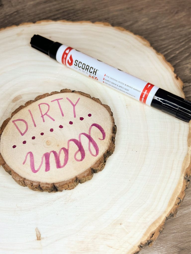 Image contains a small wood slice on top of a larger one, with a Scorch Marker Pro beside it. The words “dirty” and “clean” are written on the small wood slice.