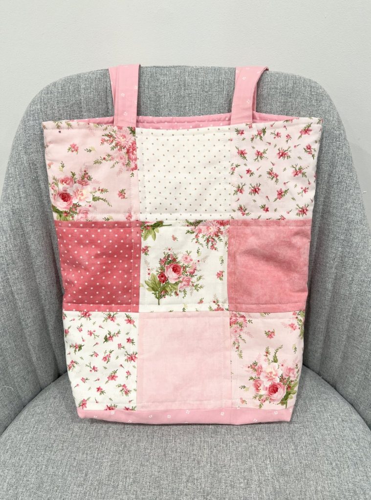 Image contains a fabric tote bag made of pink and white patchwork squares.