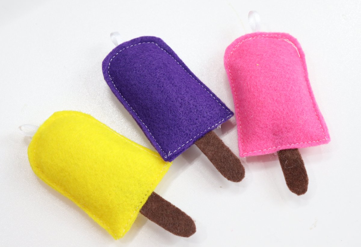 Image contains three felt popsicles; yellow, purple, and pink.