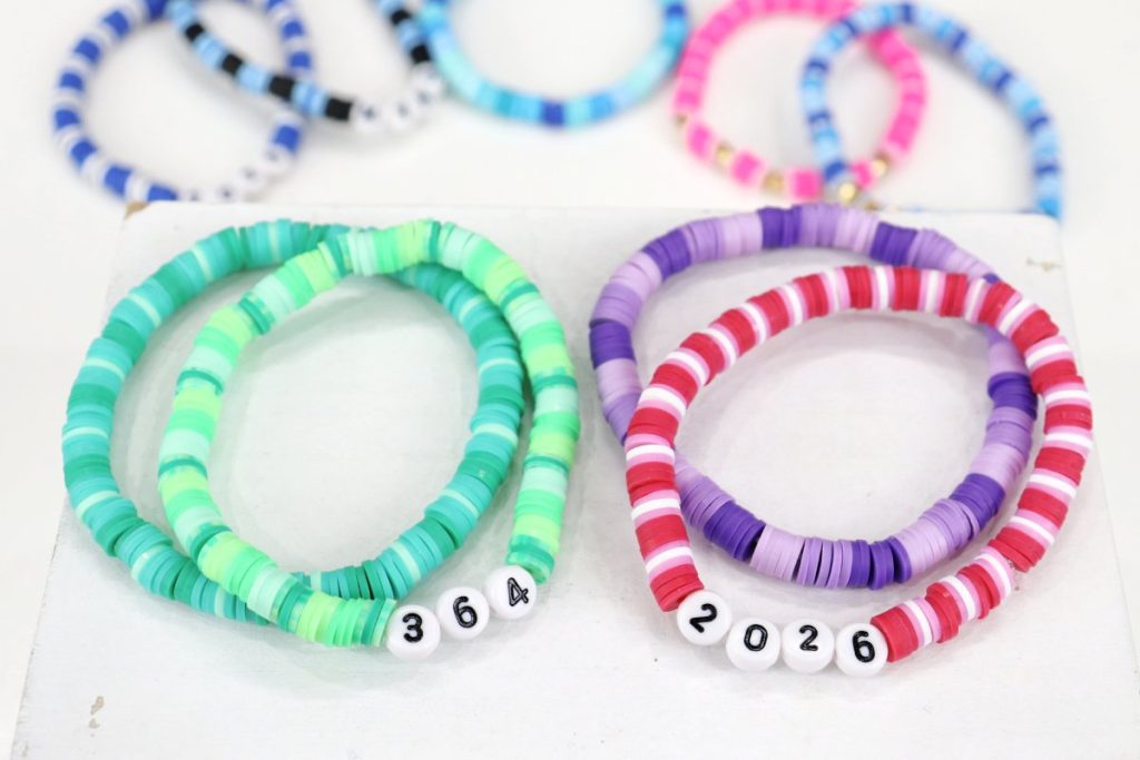 Image contains a variety of clay bead bracelets on a white background.