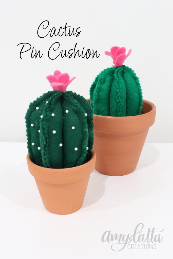 Image contains two felt cacti in terracotta pots.