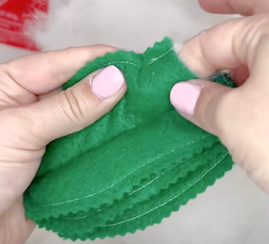 Image contains Amy’s hands stuffing Poly-Fil into one section of the felt cactus.