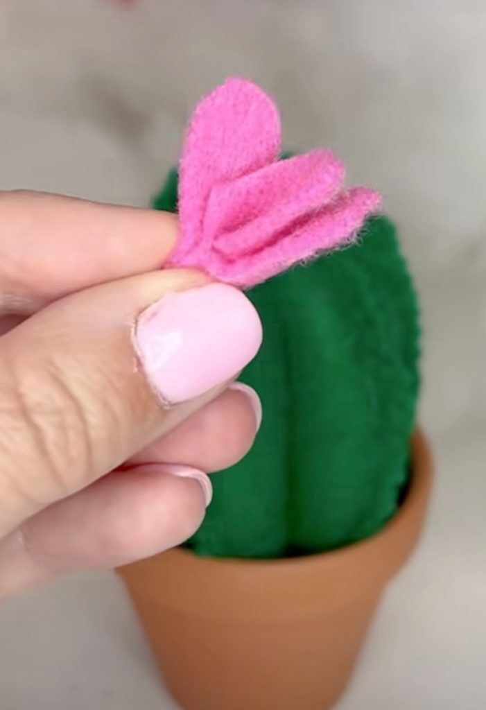 Image contains Amy’ hand holding a pink felt flower.