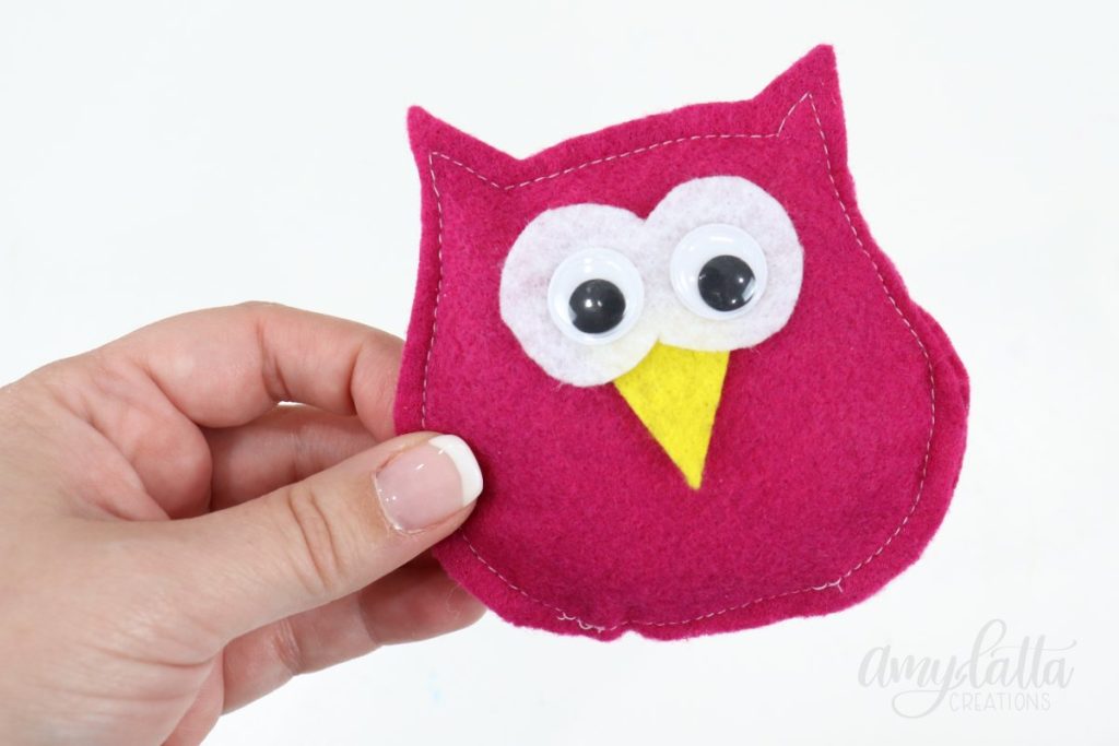 Image contains Amy’s hand holding a felt owl plush with google eyes and a yellow beak.