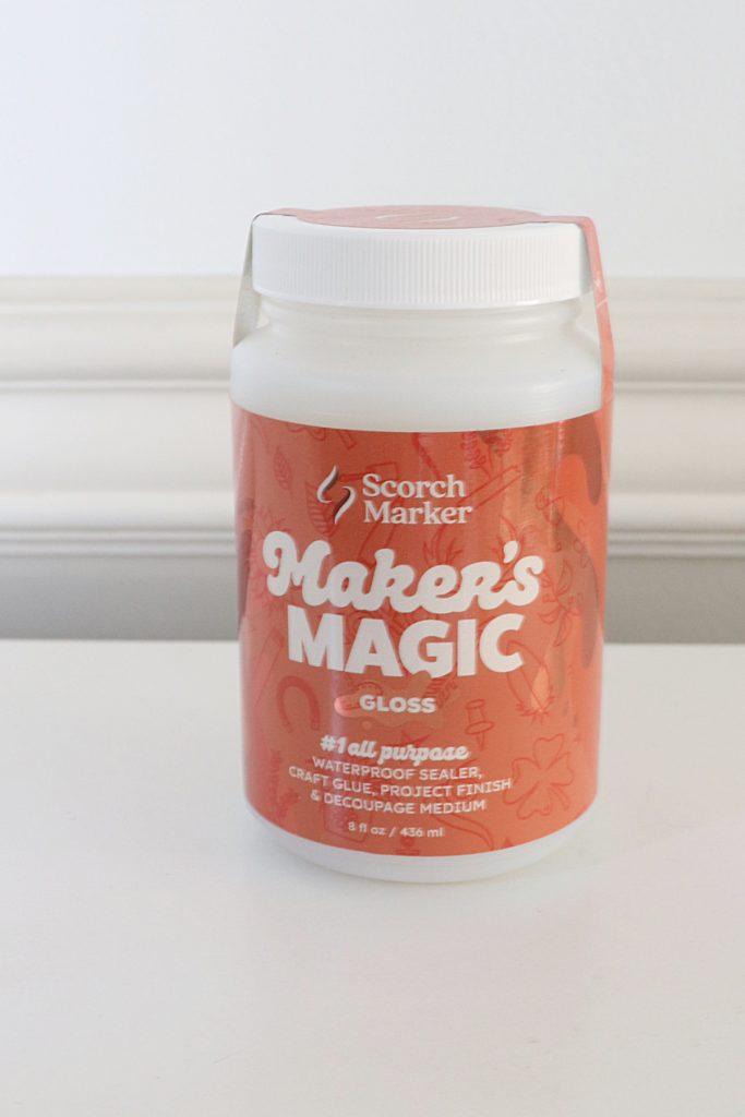 Image contains a jar of Maker’s Magic sitting on a white table with a white background.
