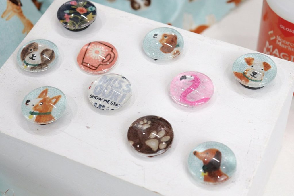Image contains 10 fabric magnets made from fabric and glass cabochons. They include several dogs, a flamingo, paw prints, flowers, and a coffee cup.