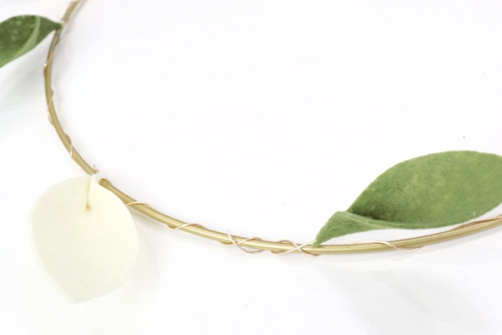 Image contains three felt leaves attached to a metal hoop with gold wire.