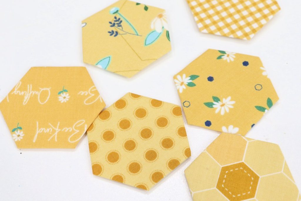 Image contains six hexagon shapes wrapped with yellow printed fabrics.