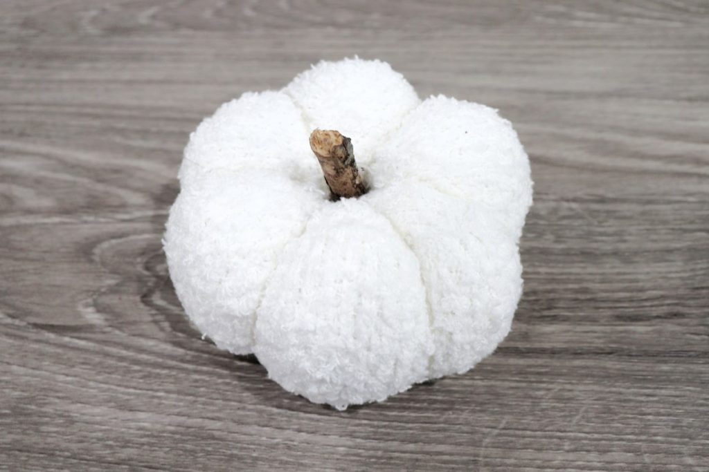 Image contains a pumpkin made from a fluffy white sock with a branch stem.