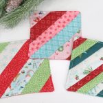 Image contains three striped fabric coasters made from a variety of red, green, white, teal, and pink holiday fabrics. A pine branch sits nearby.