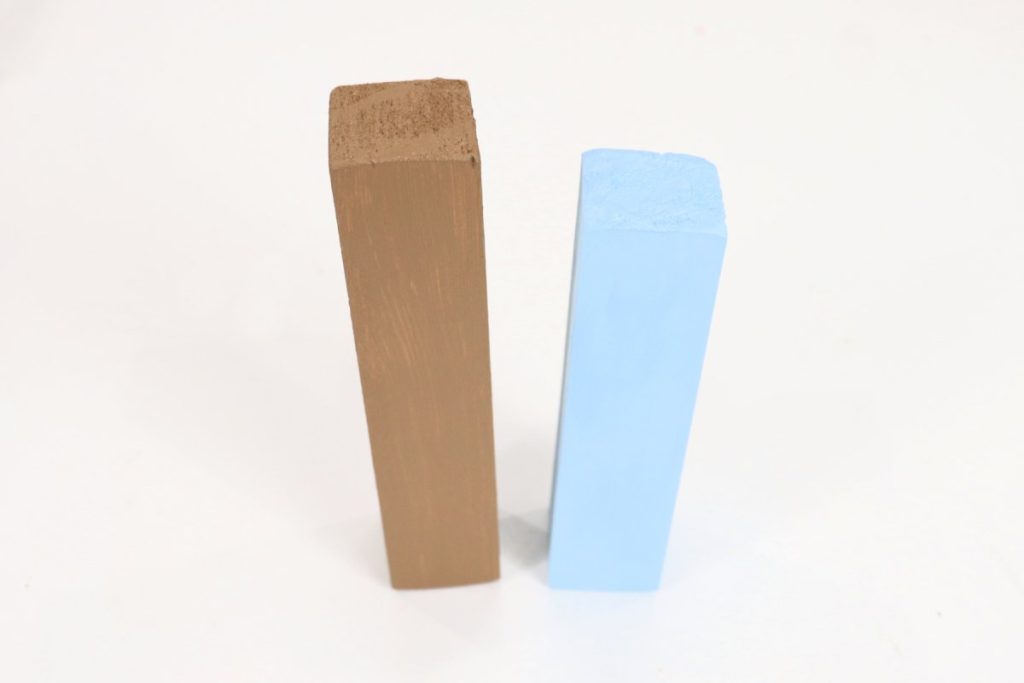 Image contains a wooden block that has been painted brown and a shorter wooden block that is painted blue.