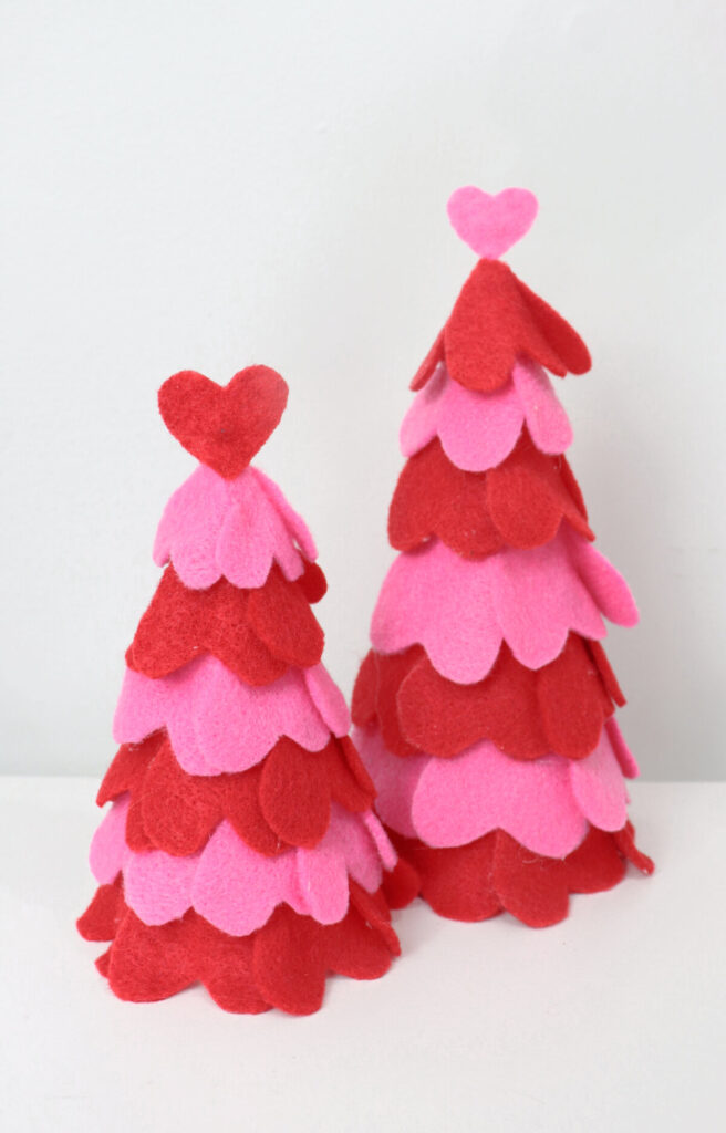 Image contains two cones covered with pink and red felt hearts.
