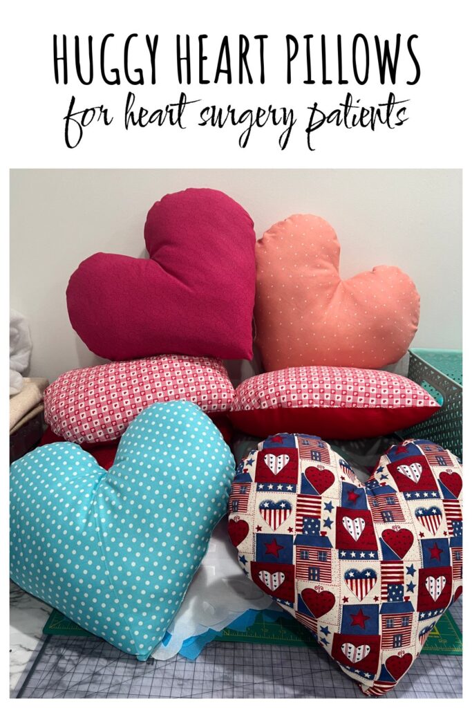 Image contains six stuffed heart shaped pillows in a variety of colors with the text “Huggy Heart Pillows for heart surgery patients."