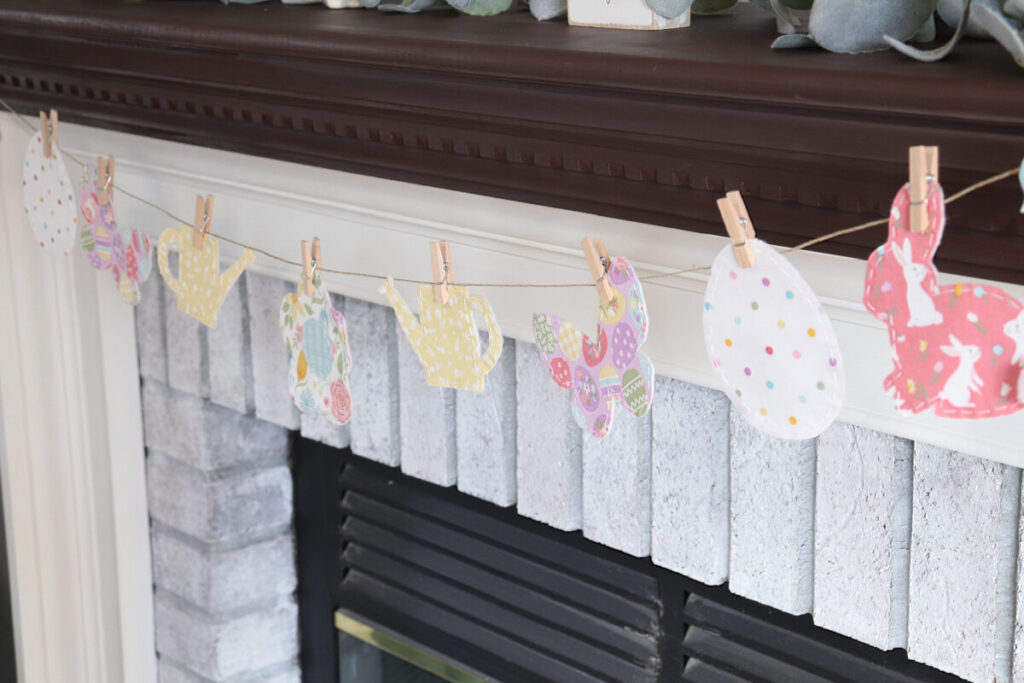 Image contains a whitewashed fireplace adorned with a multicolored spring banner.