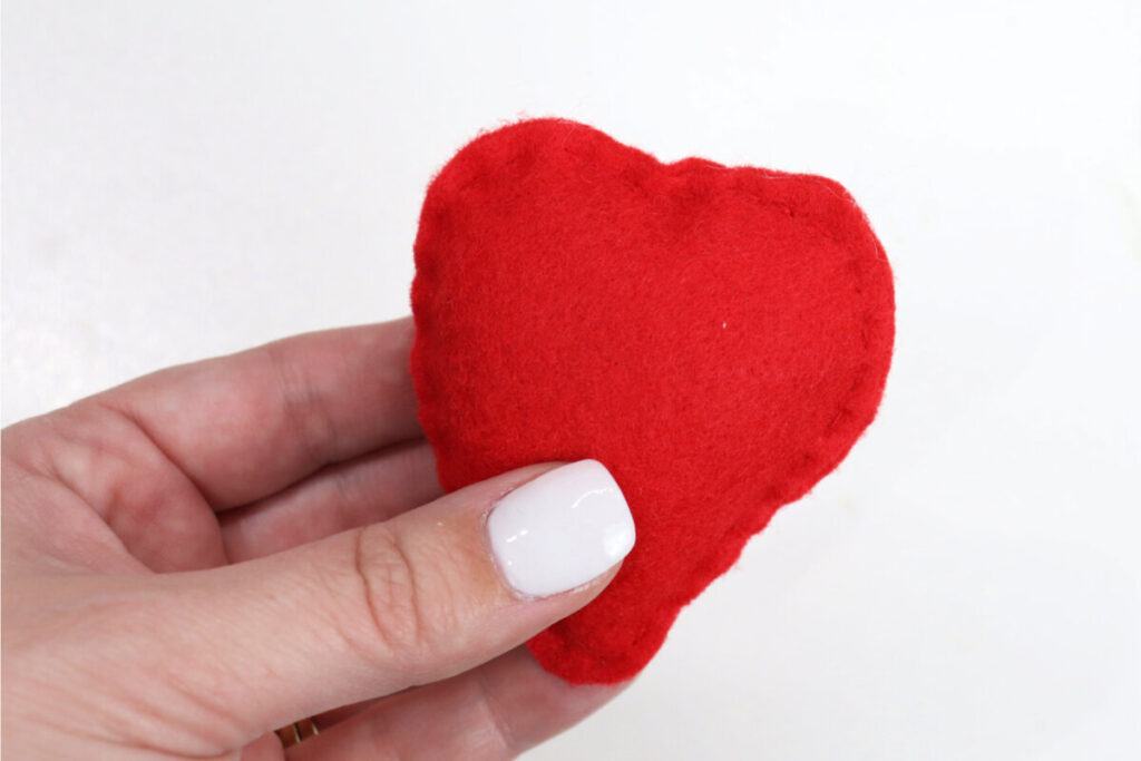 Image contains Amy’s hand holding a stuffed berry shape made of red felt.