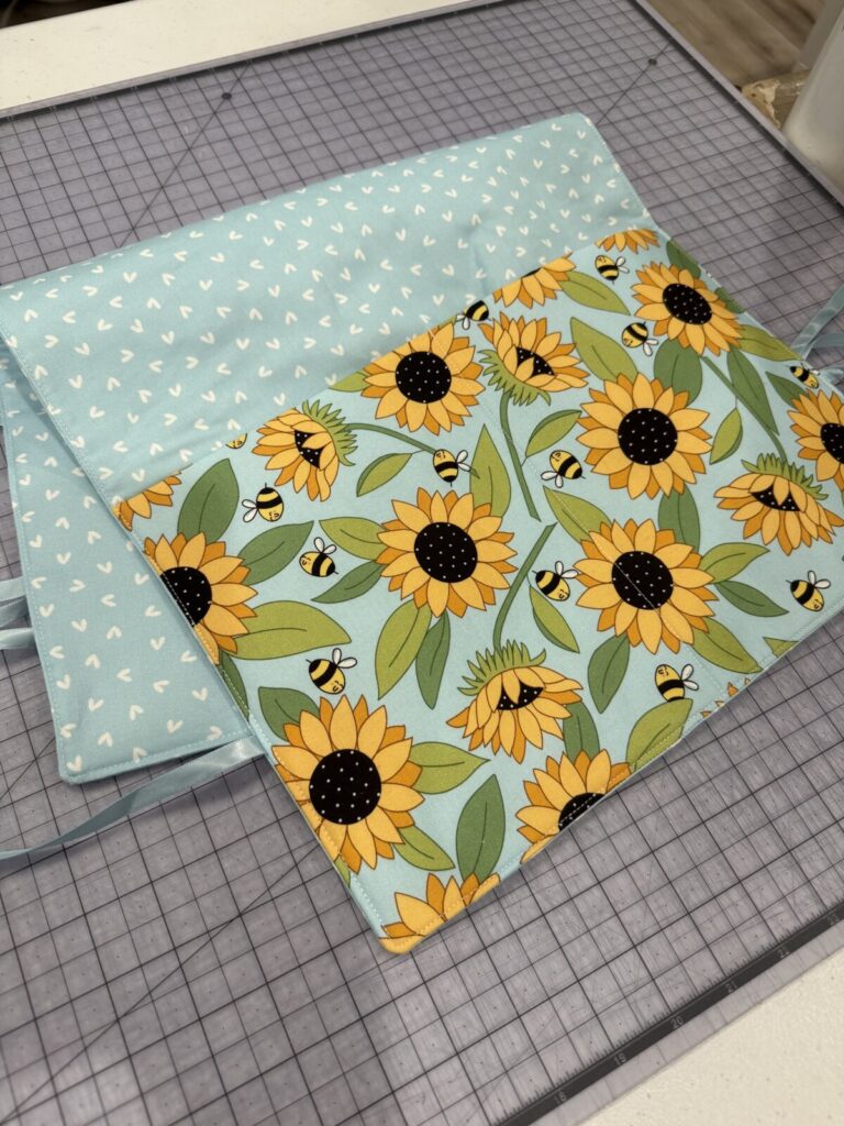 Image contains a blue and yellow walker bag laying on a transparent cutting mat.