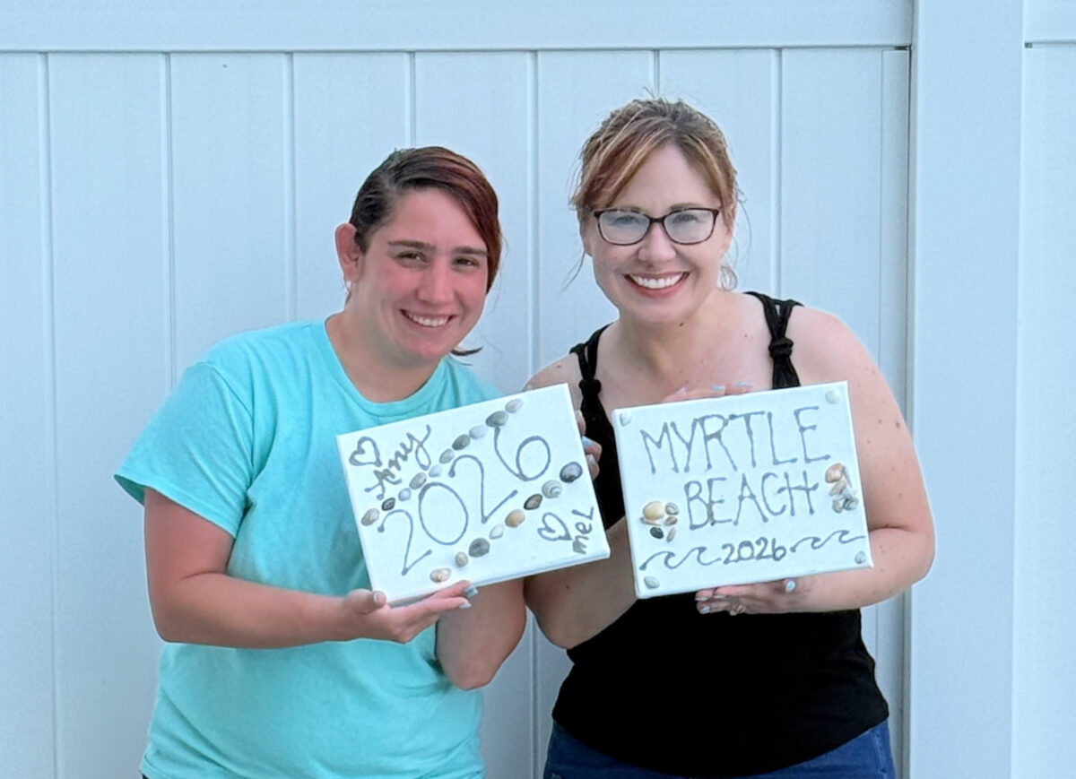 Image contains Amy and Mel holding completed Beach Vacation Canvas art.