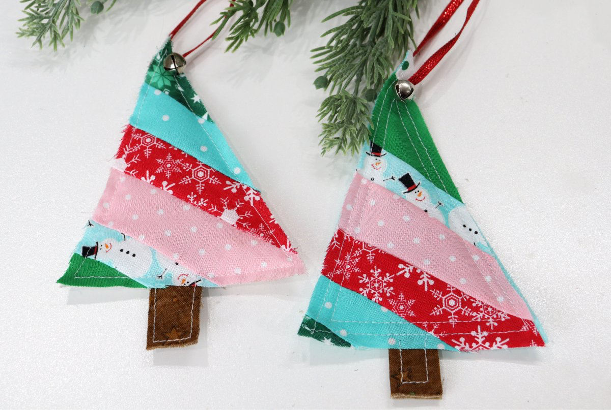Image contains two tree shaped ornaments made from scrap fabric.