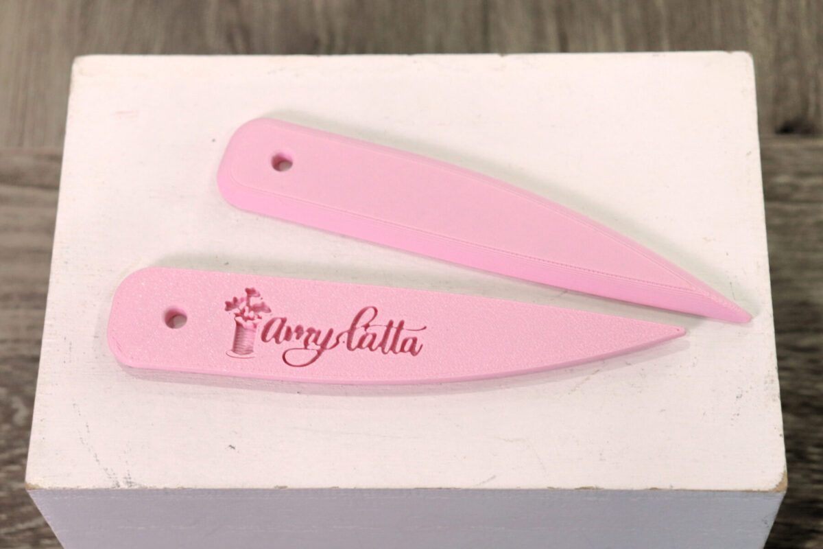 Image contains two pink point turners sitting on a white surface.