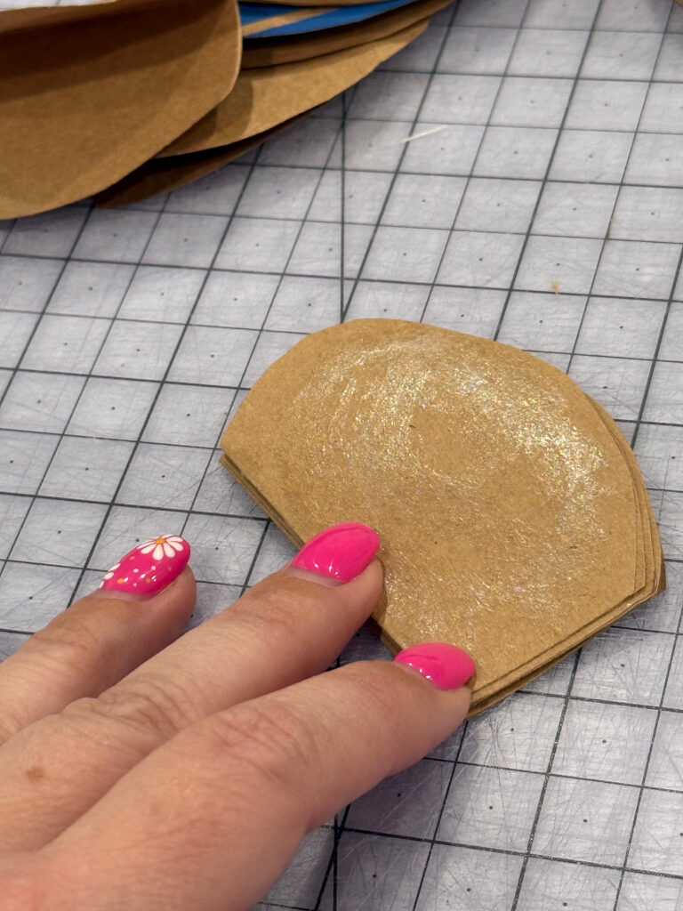 Image contains Amy's hand holding a stack of paper circles with glue on the top one.